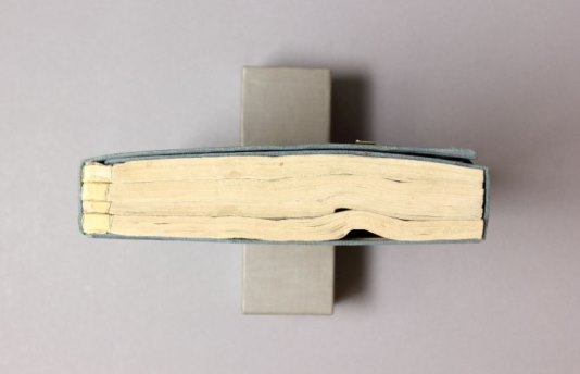 Conservation: Chinese manuscripts Bird's eye view of a bound manuscript - it is lying on its spine so the viewer can see the distortions in the pages