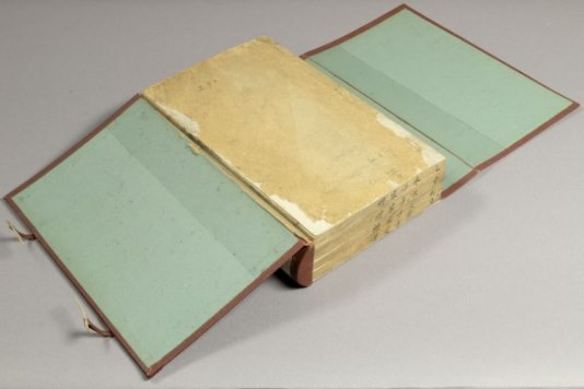 Conservation: Chinese manuscripts A large manuscript book with a hard cover - the cover is open on both sides and is light blue in colour